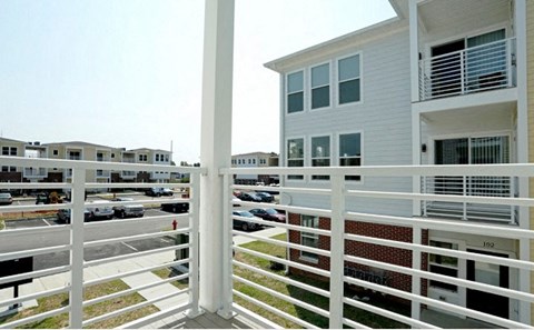 a house with a balcony overlooking a parking lot