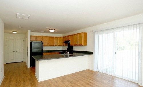 a kitchen with a counter and a black refrigerator