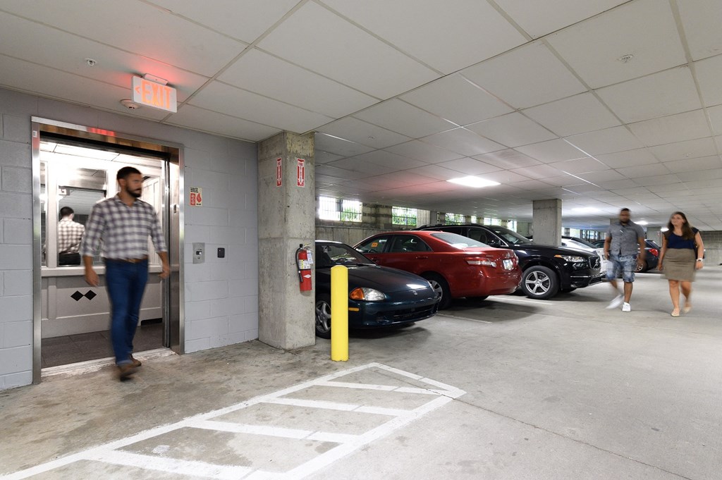 people walking into a parking garage with cars