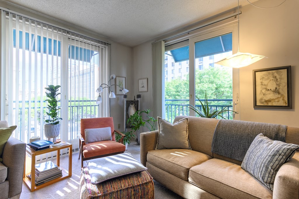 a living room with a couch and a chair and a balcony