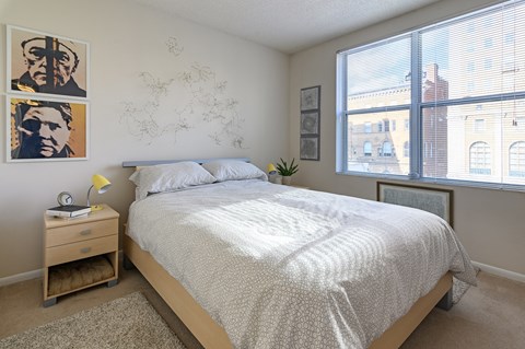 a bedroom with a bed and two large windows