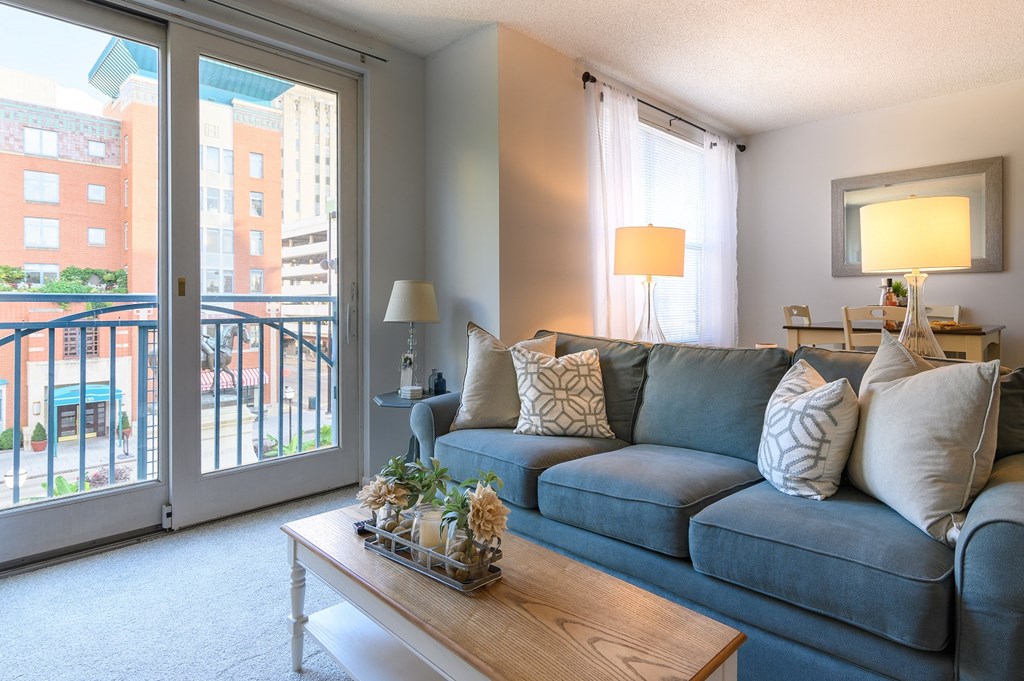 a living room with a blue couch and a sliding glass door
