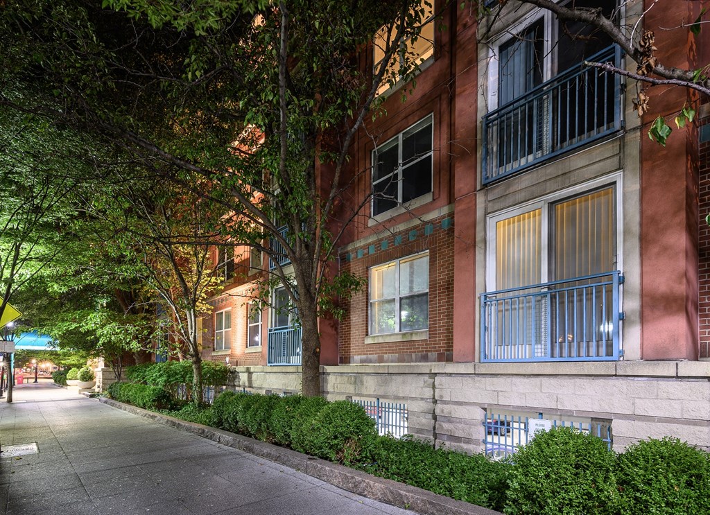 an empty street in front of a brick apartment building