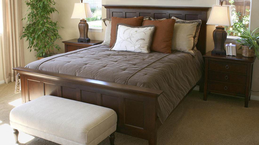 a bedroom with a bed and a stool