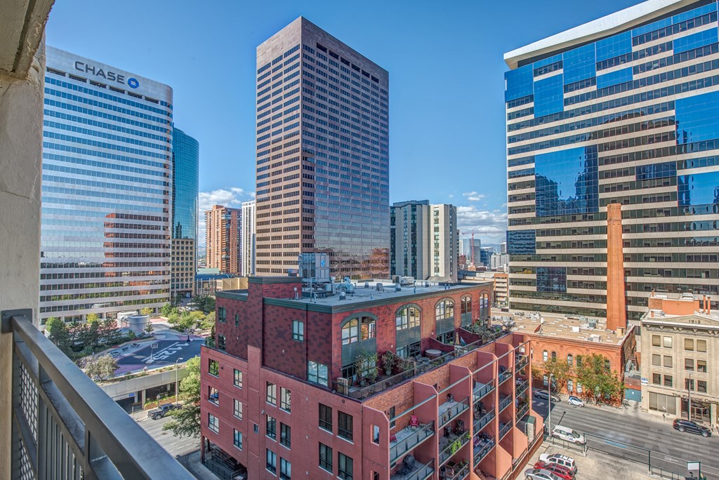 a view of a city from a balcony with tall buildings