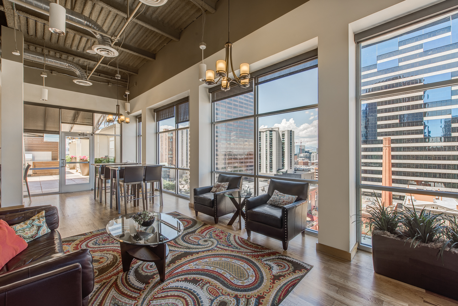 an open living room with large windows and a view of the city