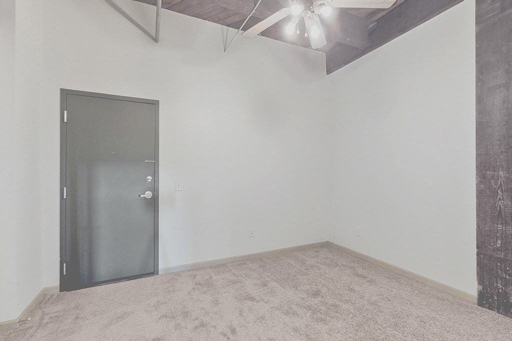 an empty room with white walls and a silver door