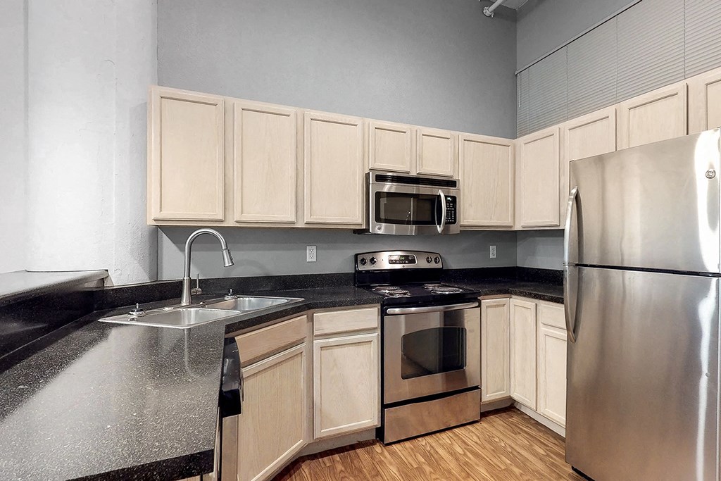 a kitchen with stainless steel appliances and black counter tops