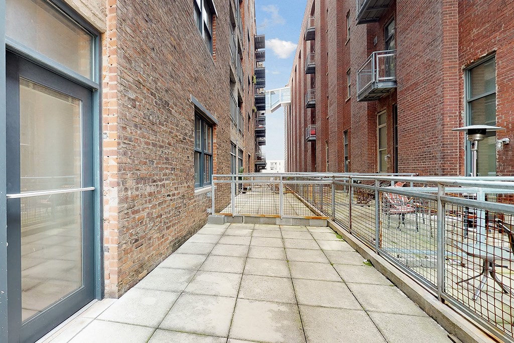 a balcony with a metal fence and a brick building