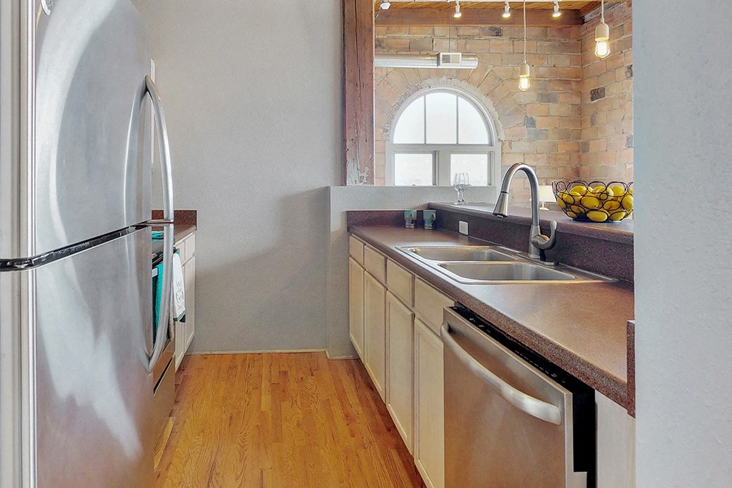 a kitchen with a sink and a stainless steel refrigerator