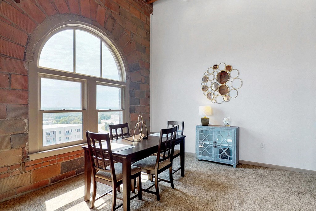 a dining room with a large window and a table and chairs