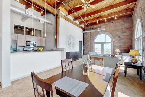 a dining room with a table and a kitchen in a loft