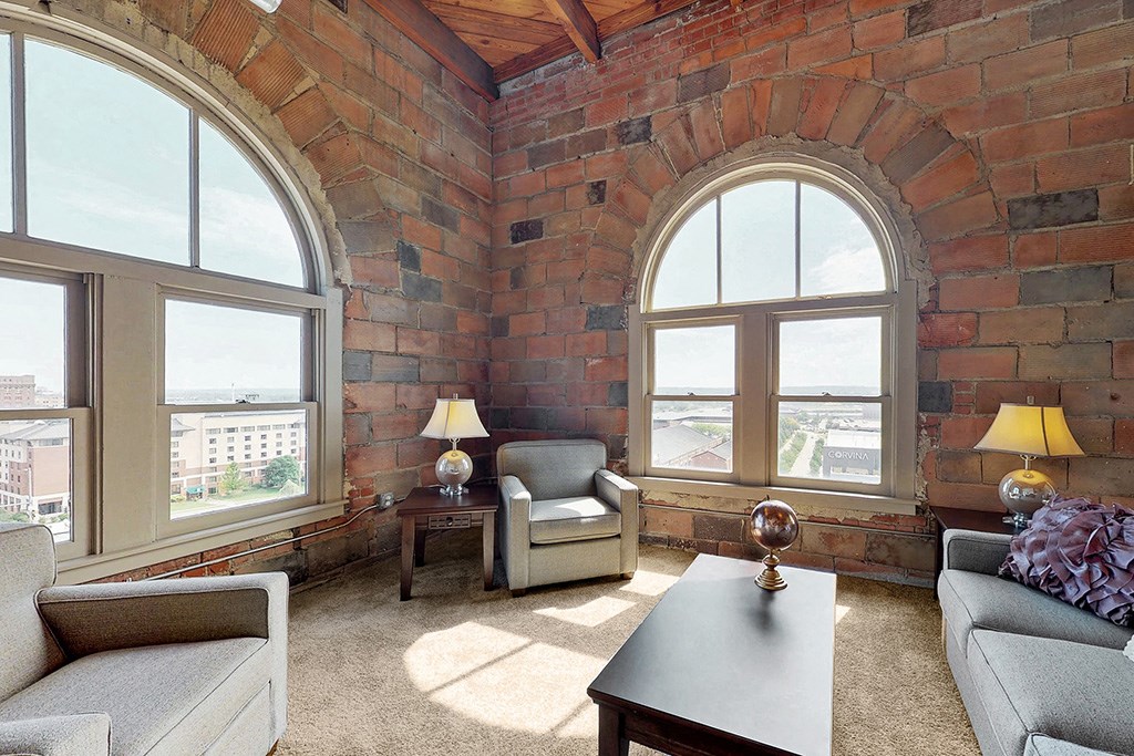 a living room with a brick wall and large windows