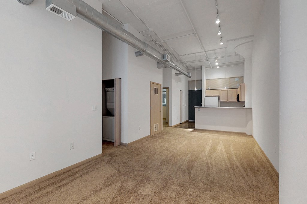 an empty room with a kitchen in the end of it