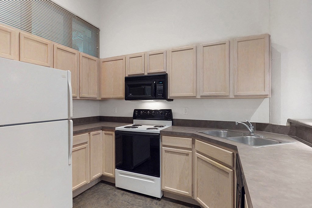 a kitchen with wooden cabinets and a stove microwave and refrigerator