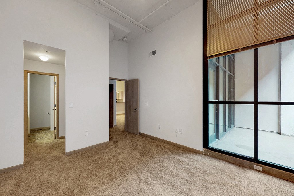 a living room with white walls and a large window
