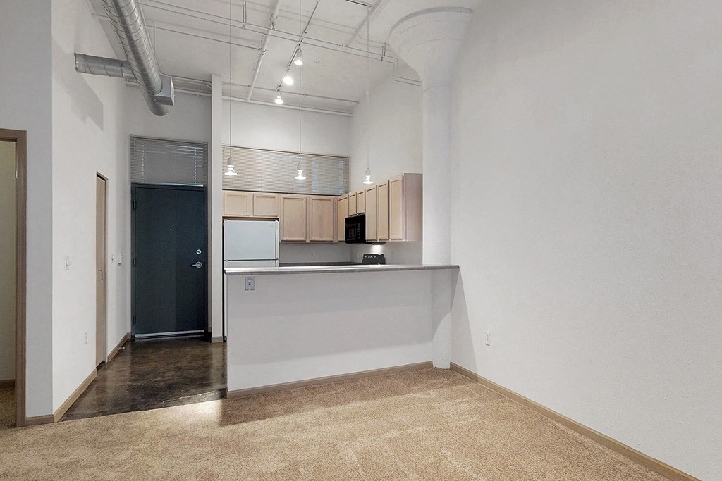 a kitchen with a counter and a door to a living room
