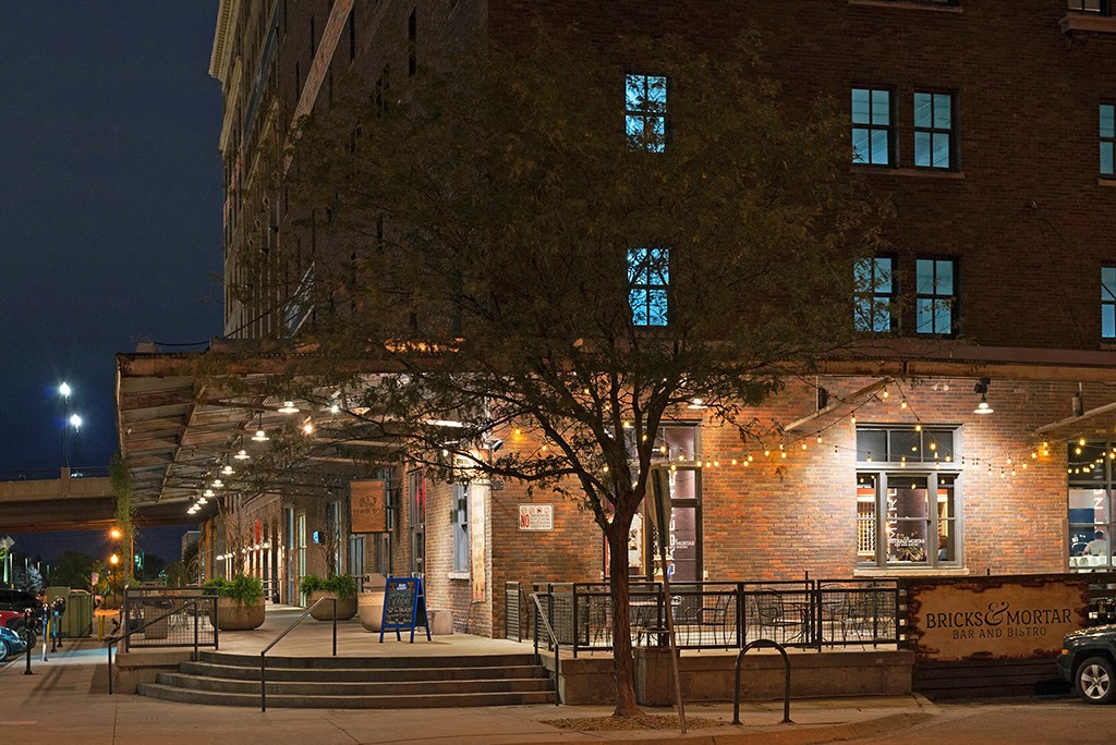 the outside of a restaurant at night with lights on the building