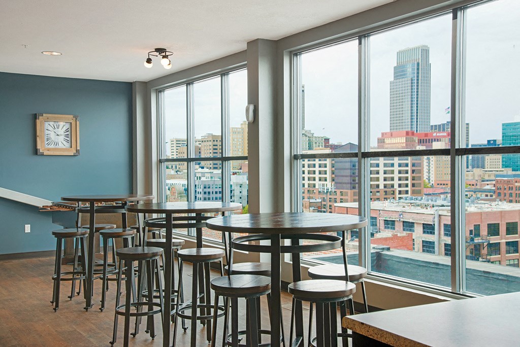 a dining area with tables and chairs and a view of the city