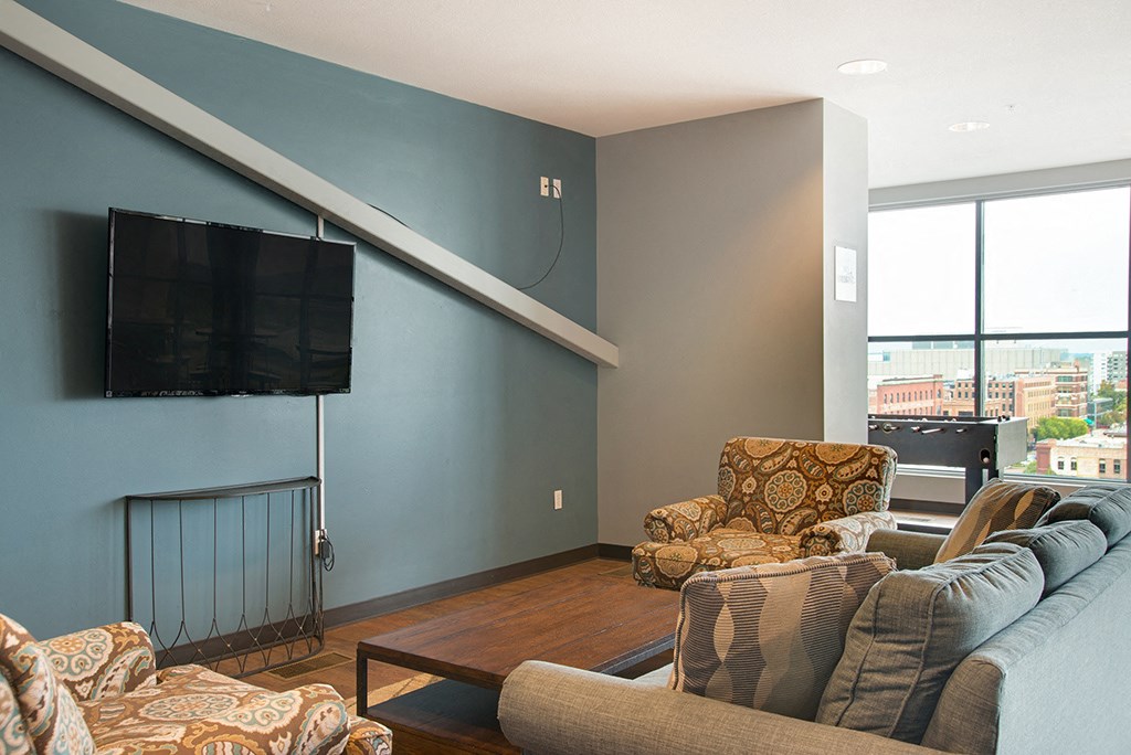 a living room with a couch and a chair and a television