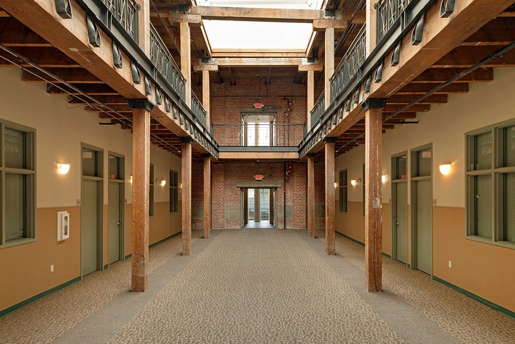 an empty corridor in a building with tall ceilings and doors