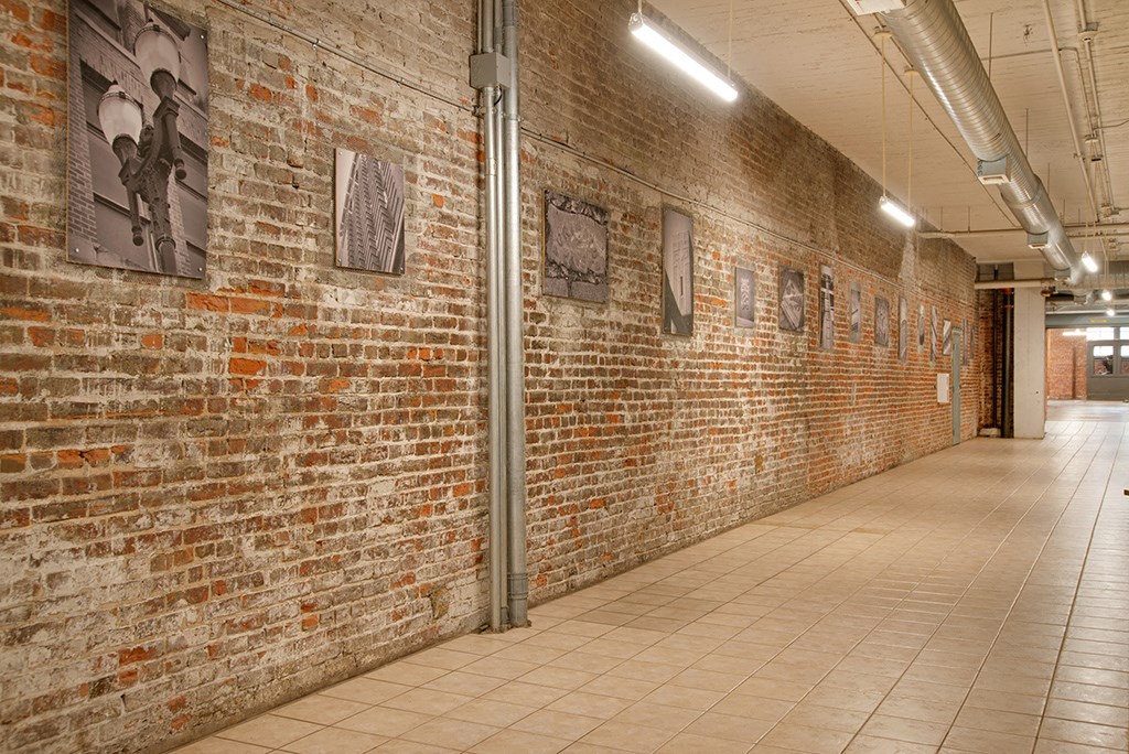 a brick wall with pictures on it in a hallway