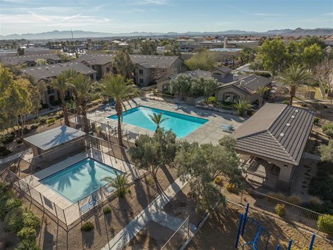 a aerial view of two swimming pools in a neighborhood with houses and trees