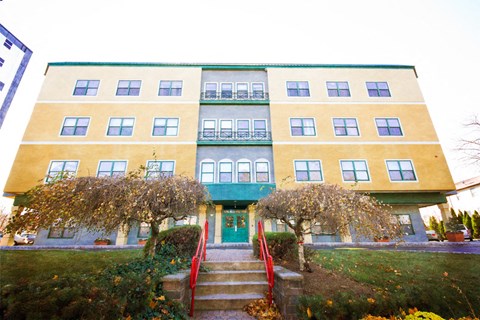 a large building with a red staircase and a green door