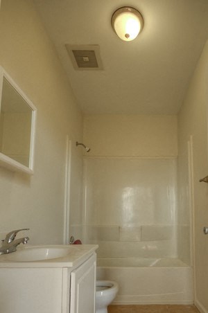 bathroom with white cabinet, white walls and being floor tile