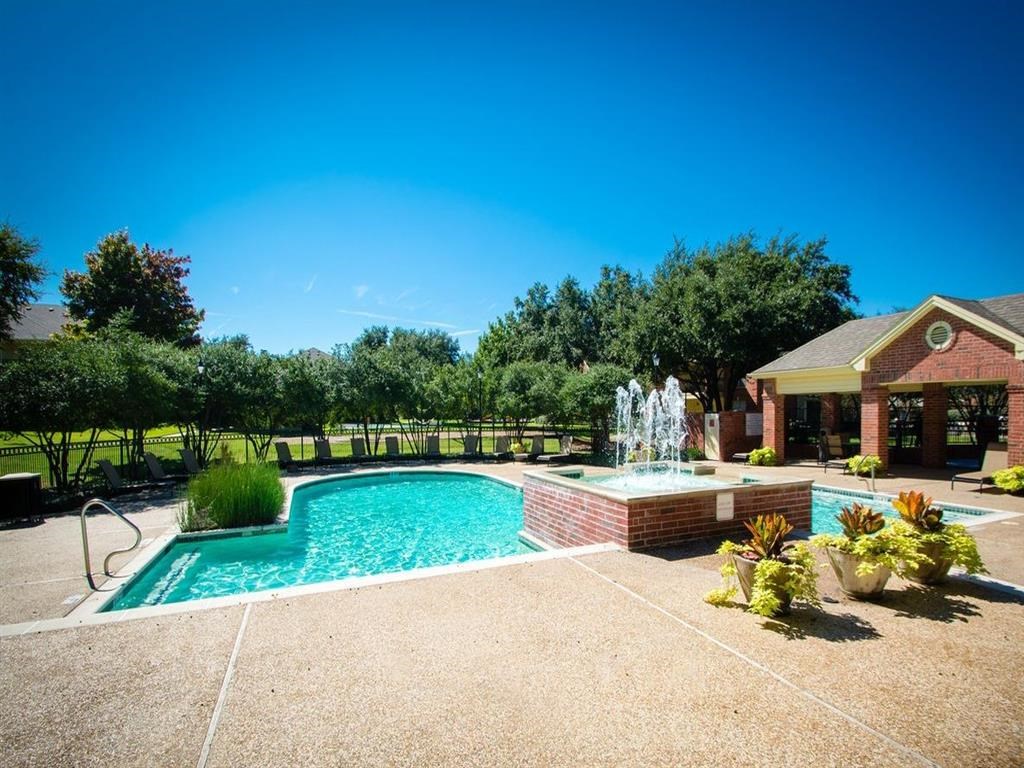 a swimming pool with a fountain in front of a house