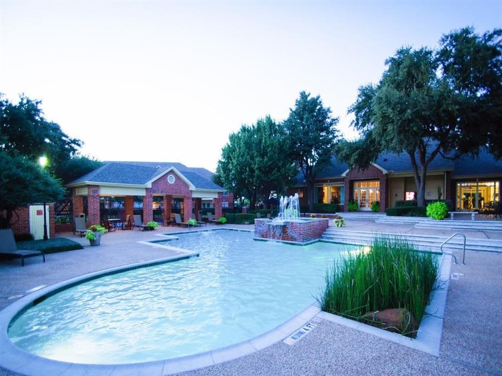a swimming pool with a fountain in front of a house