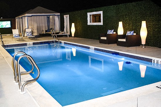 a swimming pool at night with a blue pool