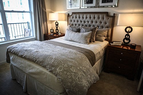 a bedroom with a bed and two lamps and a window