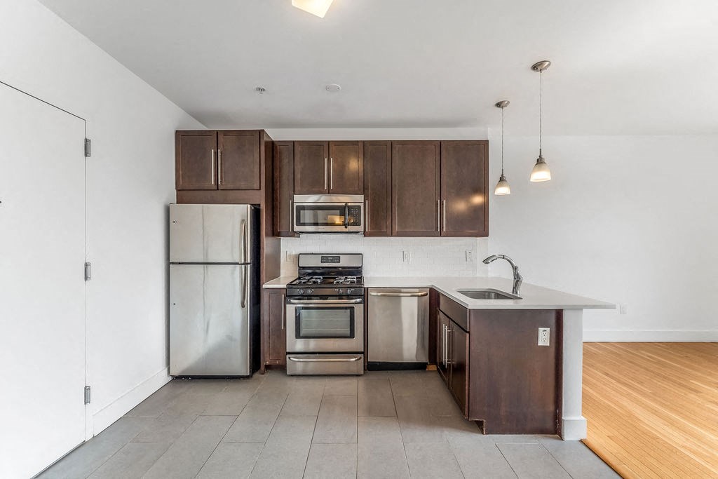 a kitchen with stainless steel appliances and wooden cabinets