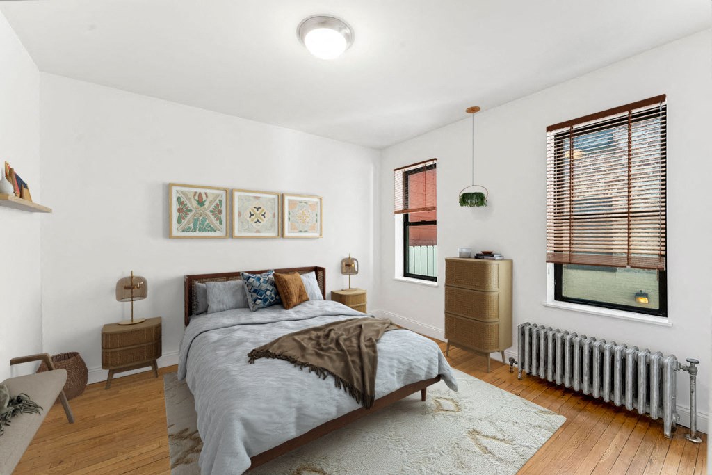 A bedroom with a bed, nightstands, and a window with blinds.