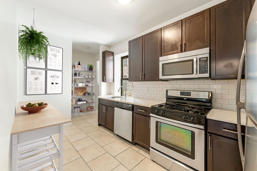 A kitchen with a white stove top oven and a microwave above it.