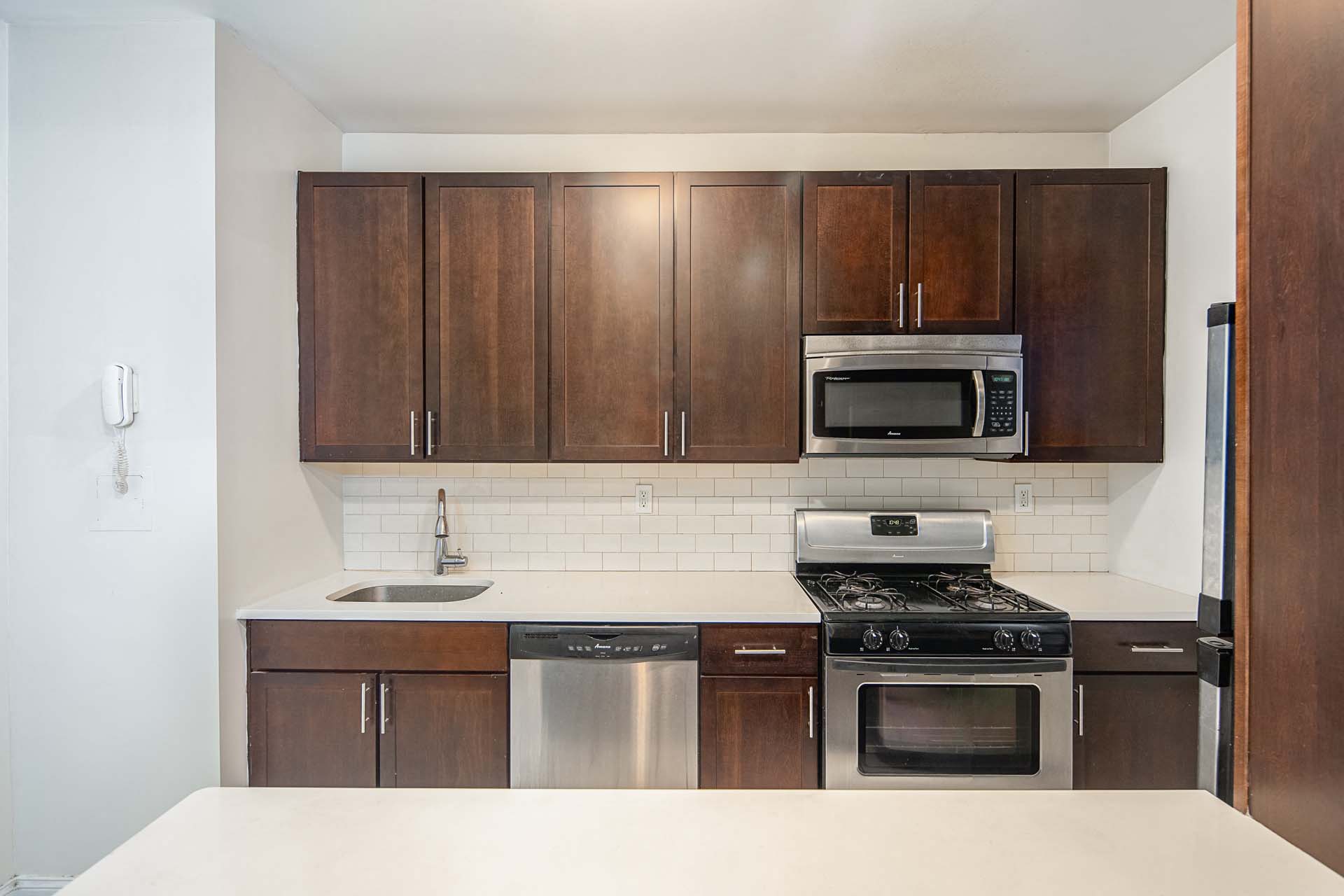 a kitchen with wooden cabinets and stainless steel appliances