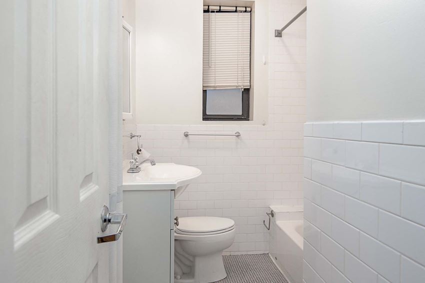 a white bathroom with a toilet and a sink