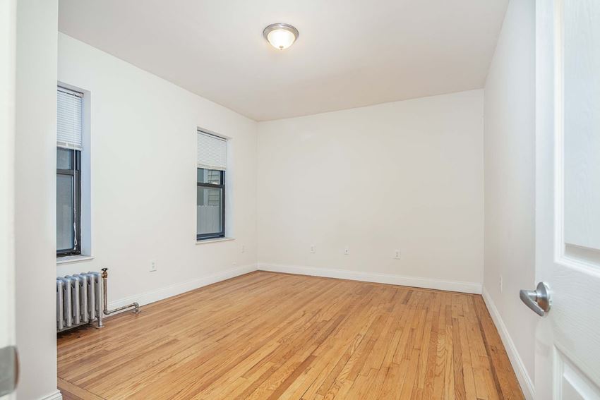 a living room with a hardwood floor and a window
