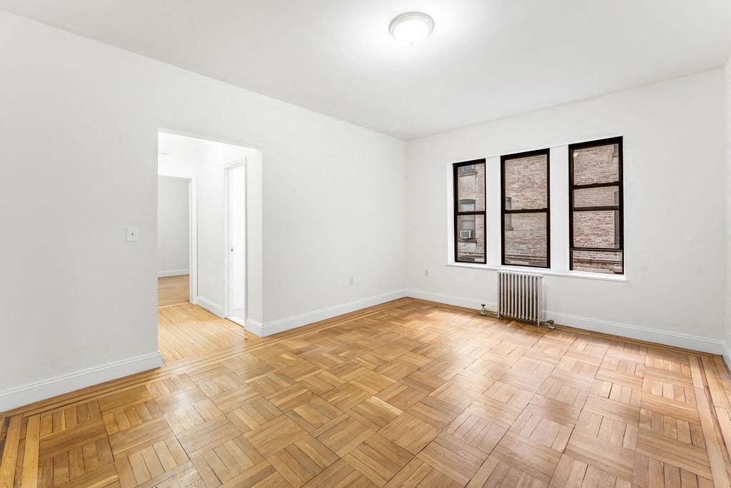 a living room with a hard wood floor and a closet