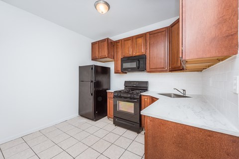 a kitchen with wooden cabinets and a black refrigerator