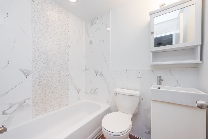 a bathroom with a toilet and a tub and a sink