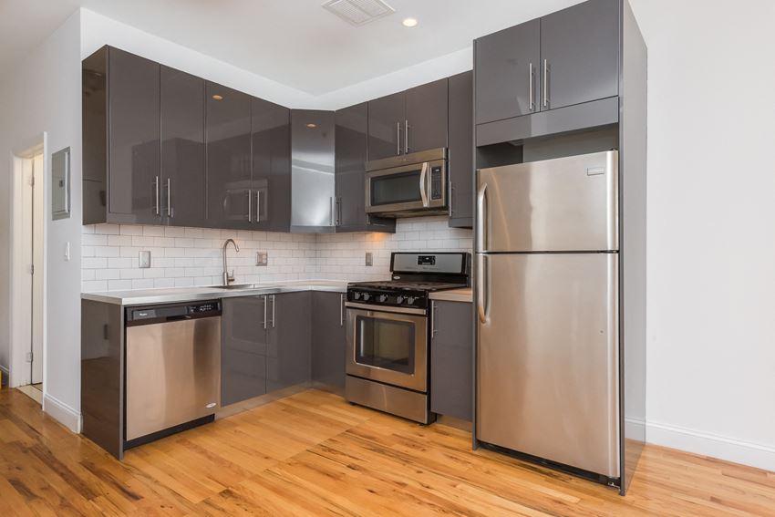 a kitchen with stainless steel appliances and black cabinets
