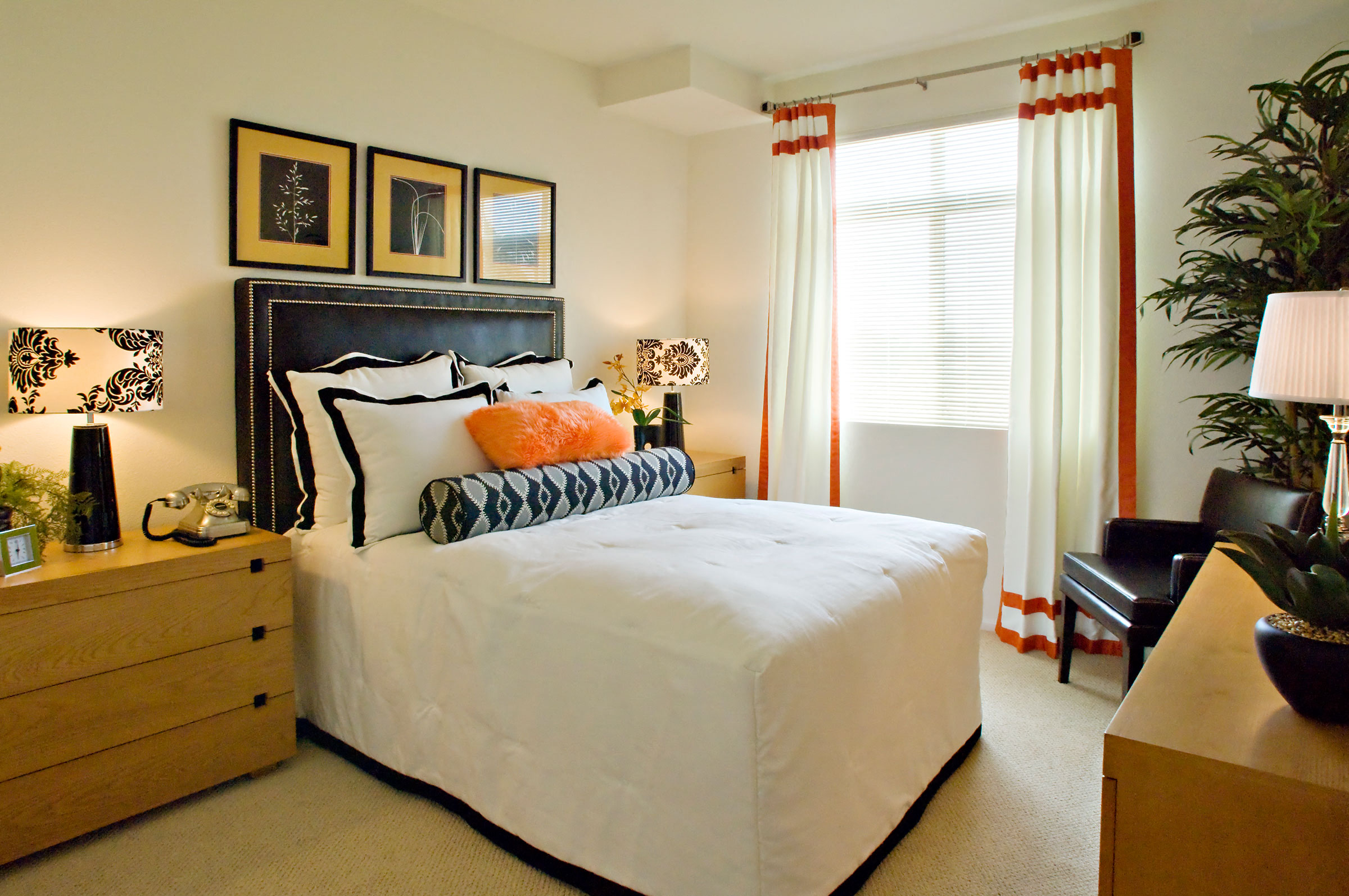 A bedroom with a large bed, a nightstand, and a chair.