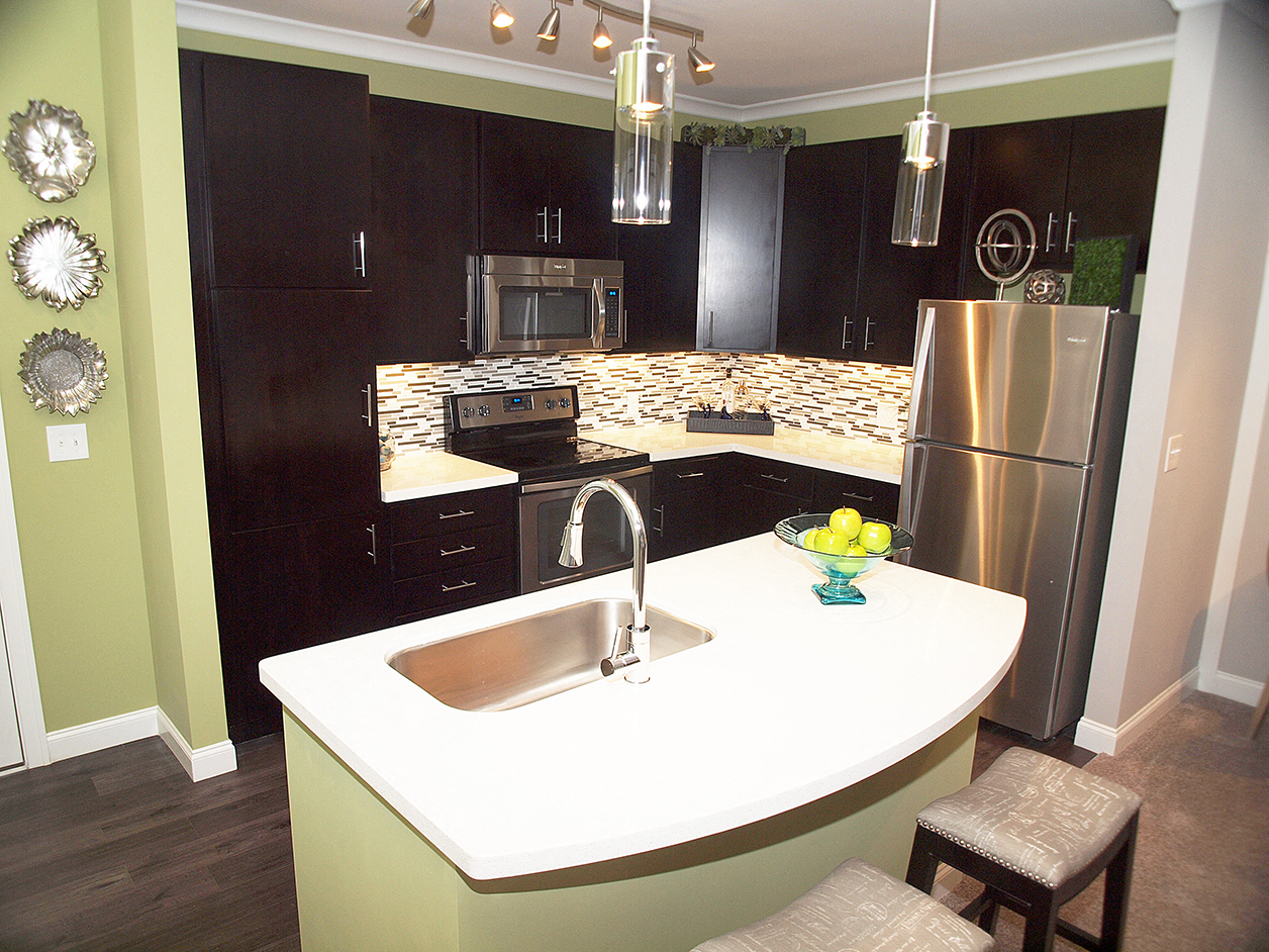 a kitchen with black cabinets and a white counter top