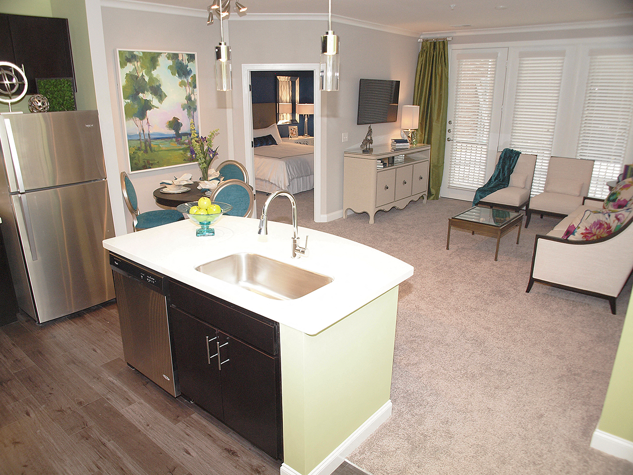 a kitchen and living room with a sink and a refrigerator