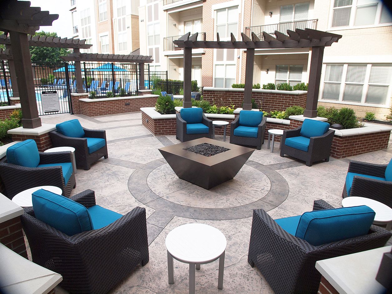 an outdoor patio with blue chairs and a fire pit
