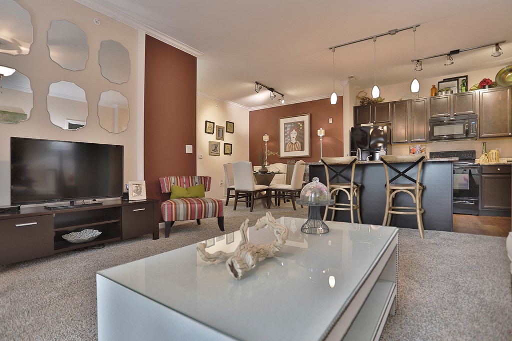 a living room and kitchen with a table and a television