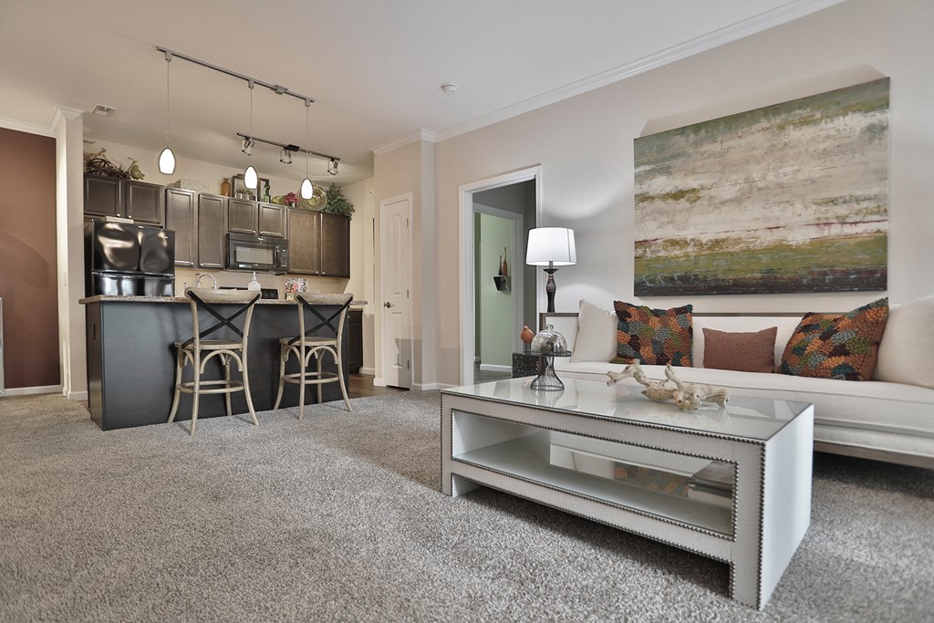 a living room and kitchen with a couch and a table
