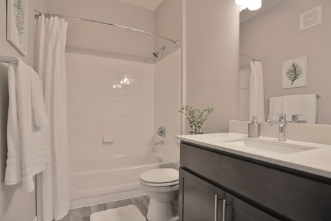 a white bathroom with a shower and a sink and a toilet